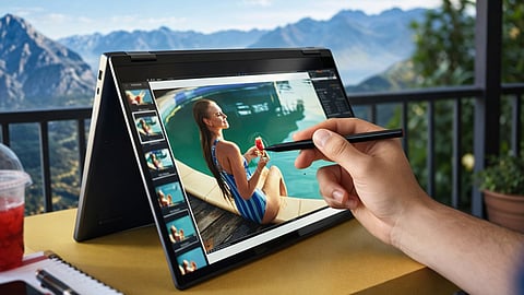 Person editing a photo on a 2-in-1 convertible laptop in tent mode using a stylus.