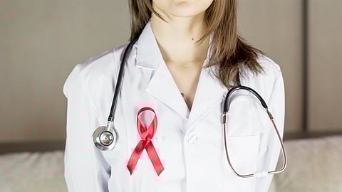 A doctor wearing a red ribbon stands in support of HIV patients amid the U.S. aid freeze/