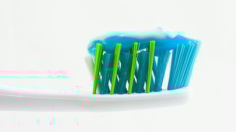 Tooth brush with toothpaste on it.