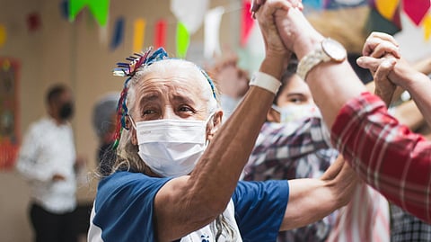 A group of people wearing face masks dance together