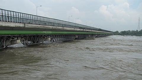Picture showing a unclean Yamuna with brownish river water.