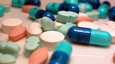 An image of various colorful pharmaceutical drugs scattered on a surface.