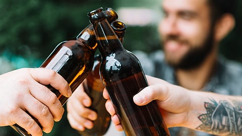 Close-up of friends are clinking the bottles at outdoors