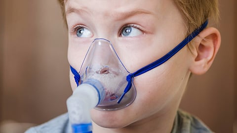 A kid wearing a mask is getting nebulised.