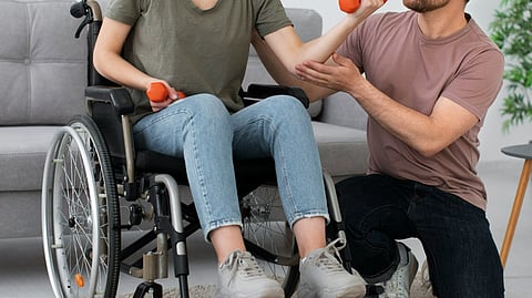 A woman on wheelchair doing exercise with dumbell 