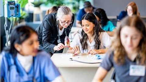 A classroom for medical professionals where a senior female faculty is teaching. 