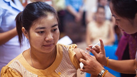 A female doctor is giving an injection to a female patient.