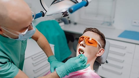 A patient getting treatment from a dentist in a dental chair.