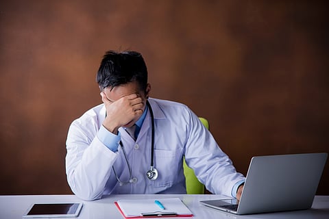 Tired Doctor working with laptop computer