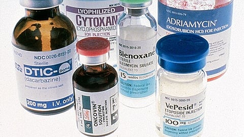 Six bottles of different types of cancer drugs over a graded blue to white background. 