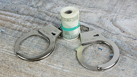 Image showing Handcuffs and dollars together representing fraud.