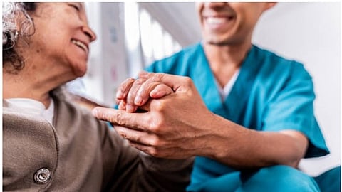 An elderly woman smiling in conversation with a doctor.