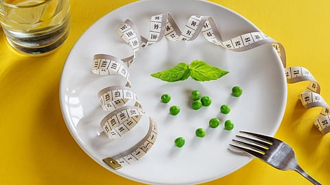 A white plate topped with peas and measuring tape
