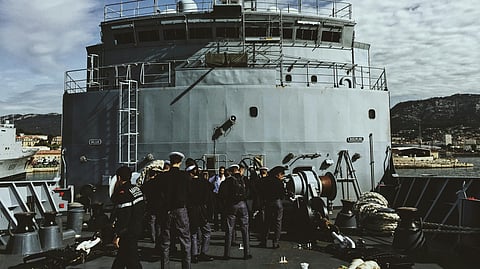 Few mariners gathered outside a ship to board.