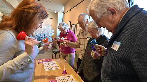 Few people playing a bell game at a table.
