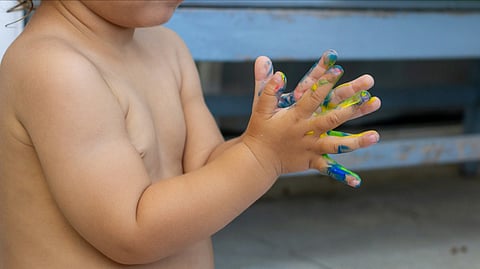 Representatioanl image of a child playing with paint