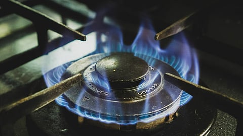 Black and white gas stove with blue flame