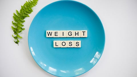 A blue round plate with tiles spelling out the words "weight loss" in the center.