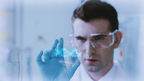 A healthcare professional using a hologram of DNA structure to analyse something.