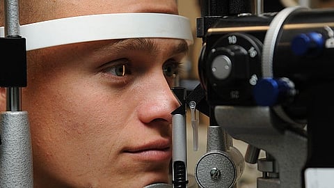 A person looking through an optometer during an eye test.