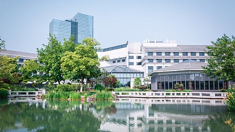 Lots of glass buildings with a lake in front represent a pharma park.