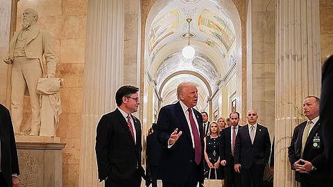 President Donald Trump is speaking to few other people in a hallway of Capitol.