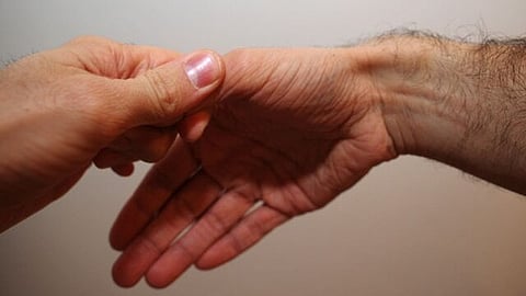 The image is showing when the examiner grasps the thumb of a person, the ulnar deviates the hand sharply.