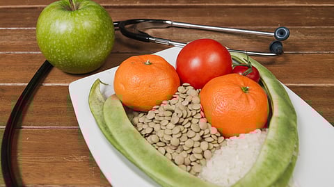 A stethoscope is wrapped around a healthy meal.