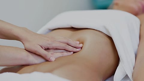 A person is getting a massage done on the stomach area.