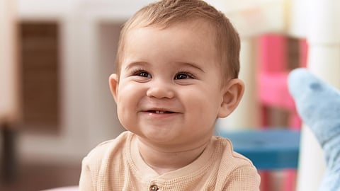Adorable toddler smiling confident sitting on sofa at home