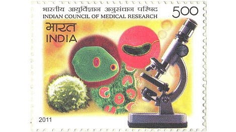 ICMR stamp featuring a microscope and bacteria, symbolizing scientific research and microbiology.