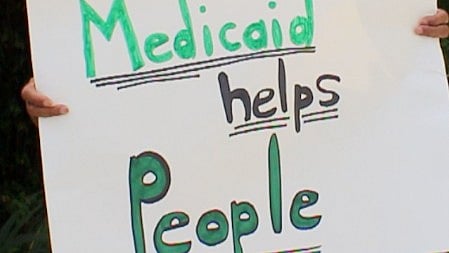 Placard saying "Medicaid helps people."