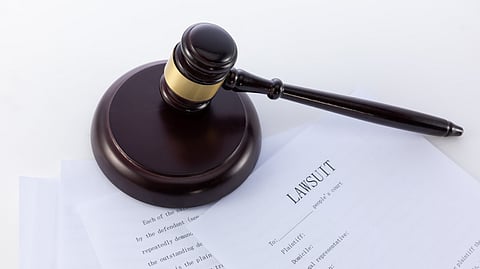 Close-up shot of Judge's gavel placed on lawsuit form.