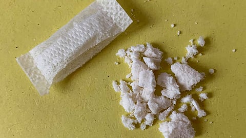 An image of a nicotine pouch content taken out from the pouch and kept on a yellow surface.