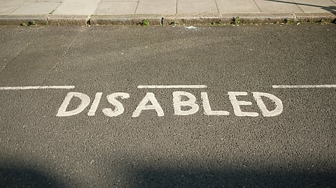 The word ‘DISABLED’ painted on road for designated parking space for disabled people.