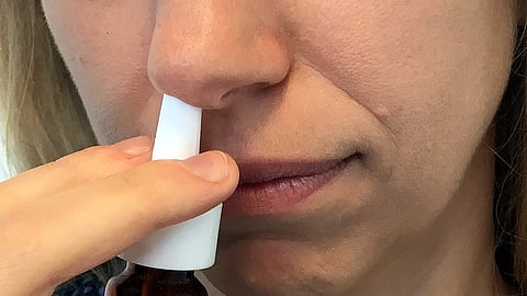A woman using nasal spray