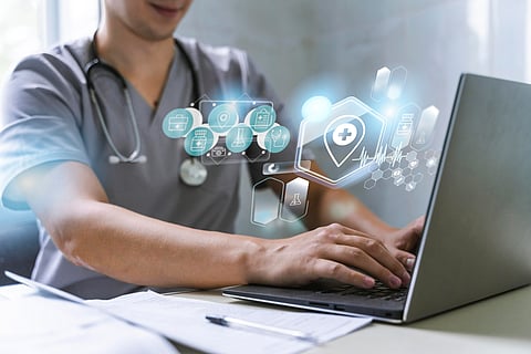 The image shows a doctor working on laptop.