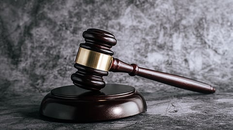 A black wooden gavel placed on a marble floor.