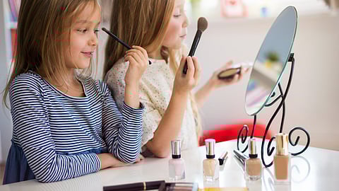 Two girls children using makeup