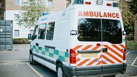 An ambulance standing in parking lot of hospital.