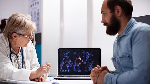 Image shows doctor and patient discussing medical visuals on laptop screen with AI application.