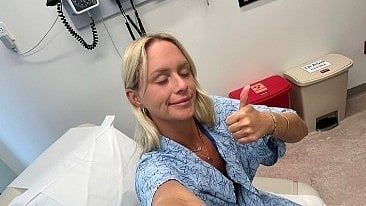 Alexis Klimpl, young breast cancer survivor, giving a thumbs-up and taking a selfie in the hospital during treatment.