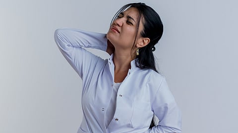 Image depicting a women holding her neck in pain.