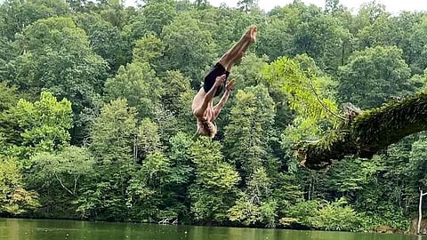James Van Der suffering from colon cancer is diving into the lake in a forest.