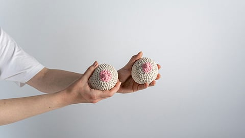 Rubber balls in the hands symbolizing breasts.