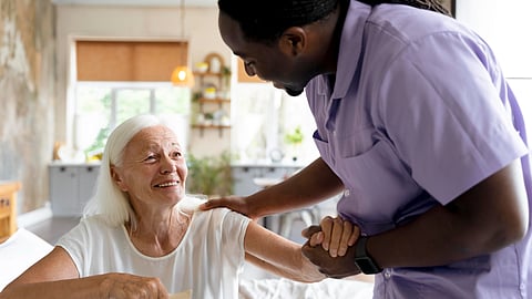 A nurse from a home care service providing care to an older adult.
