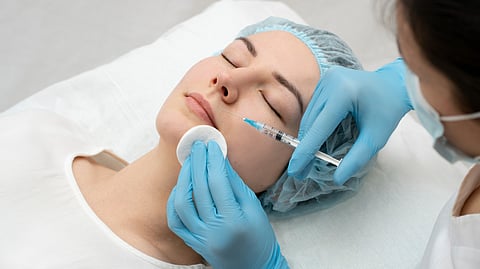 Close-up shot of a woman getting a cosmetic procedure done in a clinical setting.