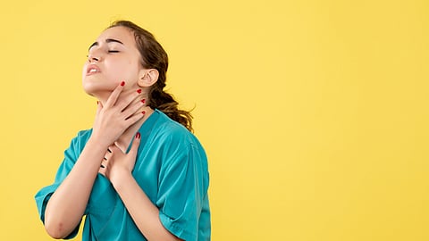 Front view of a young female doctor in medical suit on yellow background.