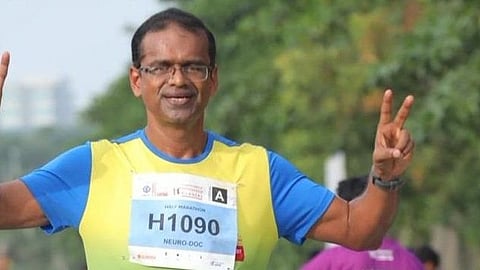 Image of Dr. Sudhir Kumar wearing a yellow color t-shirt and showing victory sign.