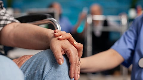 A close-up image of someone consoling another person by placing a reassuring hand on the other.